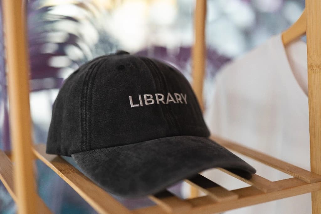 Library branded cap displayed on a wooden shelf