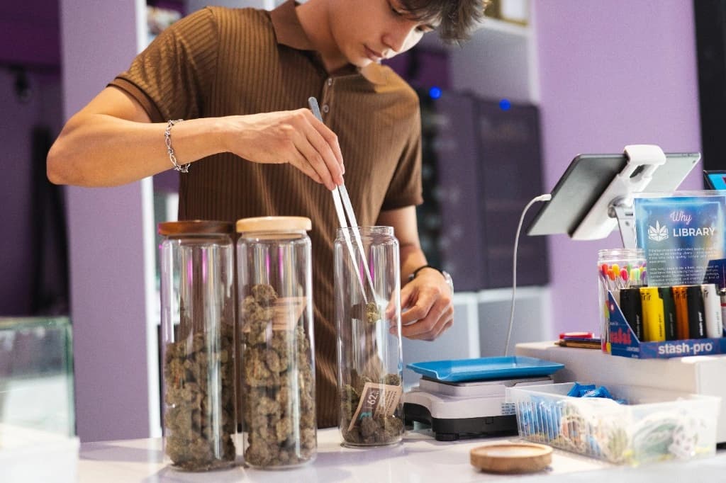 Staff member preparing cannabis flower at the service counter